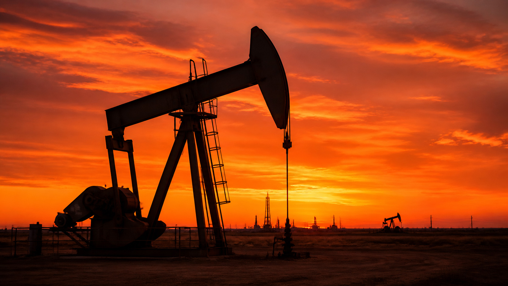 Oil and gas production equipment at sunset